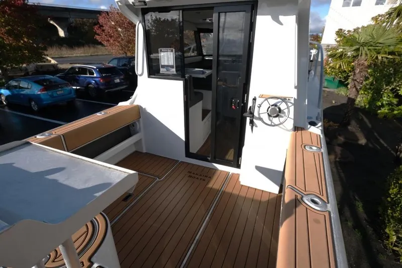 Slide: The Image of 2023 Makaira Sportfish 800 boat deck with seating and steering wheel. - 9