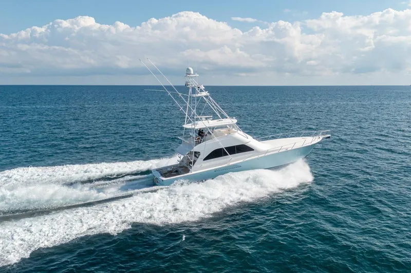 Slide: The Image of 2006 Viking 68 Convertible yacht cruising on open ocean under clear skies. - 12