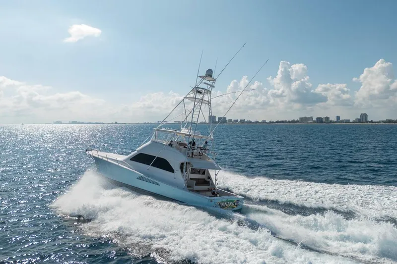Slide: The Image of 2006 Viking 68 Convertible yacht cruising on open water under a clear sky. - 13