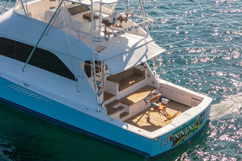 Slide: The Image of 2006 Viking 68 Convertible yacht on sparkling blue water, featuring spacious deck and seating area. - 4