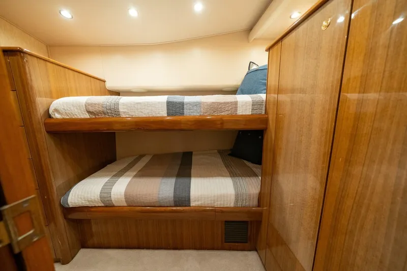 Slide: The Image of Bunk beds in 2006 Viking 68 Convertible yacht cabin with wood paneling. - 44