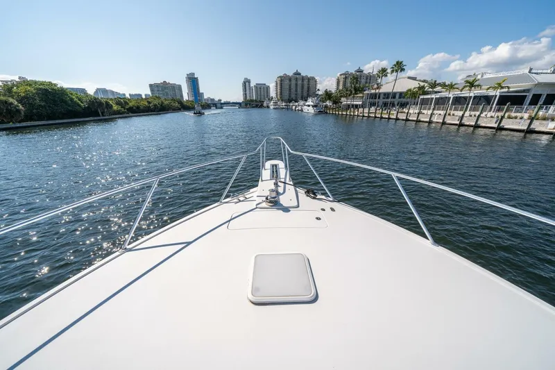 Slide: The Image of Bow view of 2006 Viking 68 Convertible yacht cruising in a sunny urban waterway. - 58