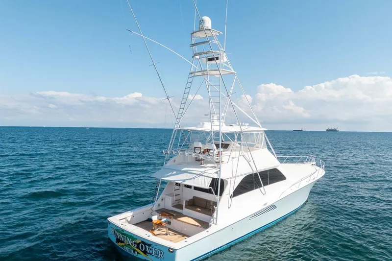 Slide: The Image of 2006 Viking 68 Convertible yacht on open sea under clear blue sky. - 6