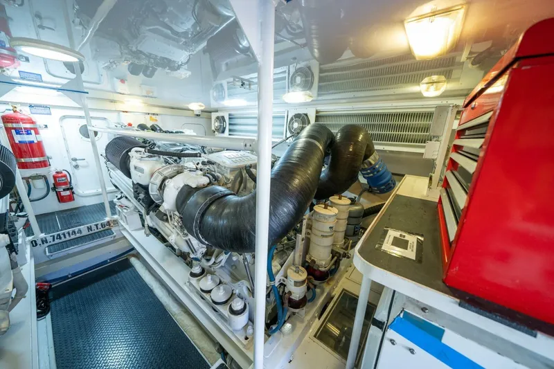 Slide: The Image of Engine room of a 2006 Viking 68 Convertible yacht, featuring machinery and tools. - 65