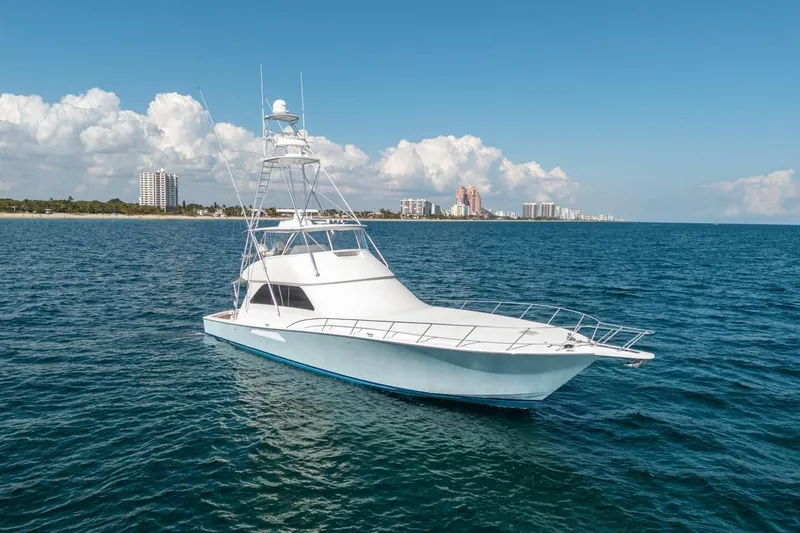 Slide: The Image of 2006 Viking 68 Convertible yacht on open sea with city skyline in background. - 7