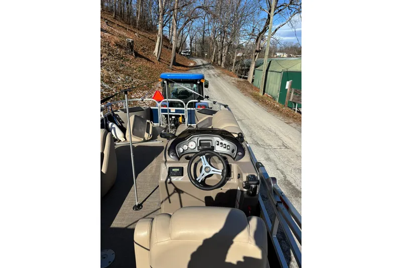 Slide: The Image of 2023 Sun Tracker Fishin' Barge 20 DLX on a road, surrounded by trees. - 12