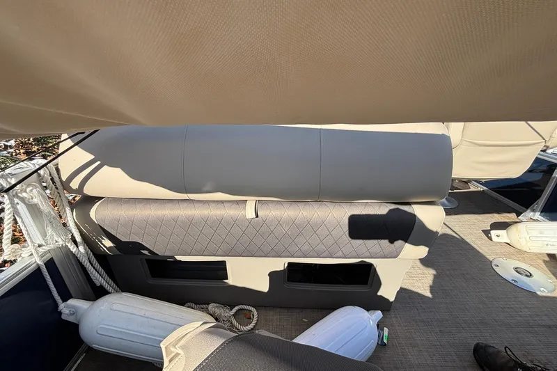 Slide: The Image of 2023 Sun Tracker Fishin' Barge 20 DLX interior seating with beige upholstery and storage. - 8