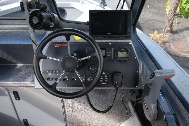 Slide: The Image of 2017 North River 21 SEAHAWK boat dashboard with steering wheel and navigation controls. - 15