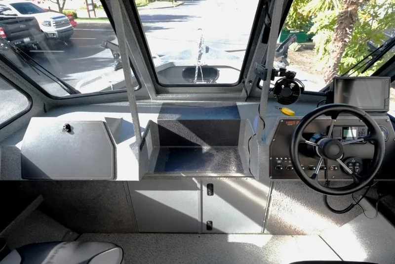 Slide: The Image of 2017 North River 21 SEAHAWK boat interior with steering wheel and dashboard controls. - 16