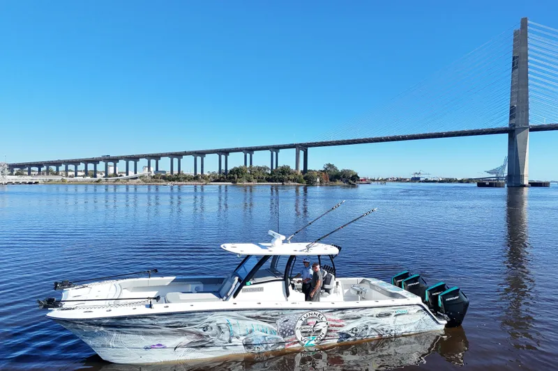 Slide: The Image of 2024 Front Runner 37 Catamaran on water near a large bridge, clear blue sky. - 47