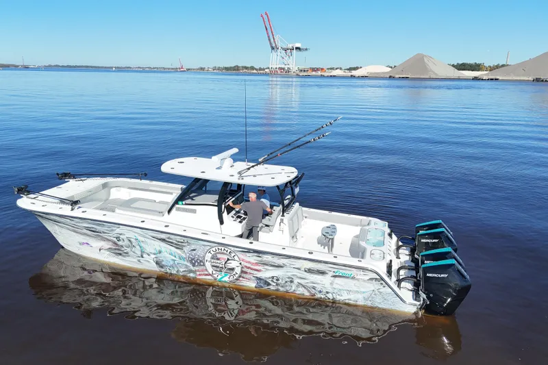 Slide: The Image of 2024 Front Runner 37 Catamaran on calm water, featuring vibrant graphics and powerful Mercury engines. - 57