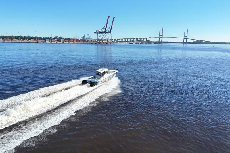 Slide: The Image of 2024 Front Runner 37 Catamaran cruising on a river near a bridge and industrial port. - 74