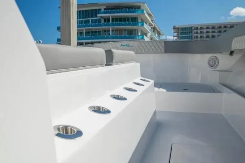 Slide: The Image of 2024 Front Runner 37 Catamaran interior with modern seating and cup holders, docked near buildings. - 87