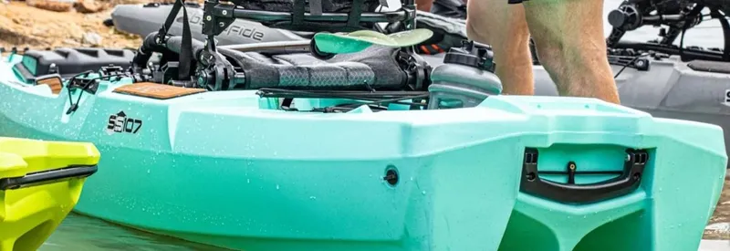Slide: The Image of 2023 Bonafide SS107 kayak in turquoise, equipped for fishing, on a lake. - 1