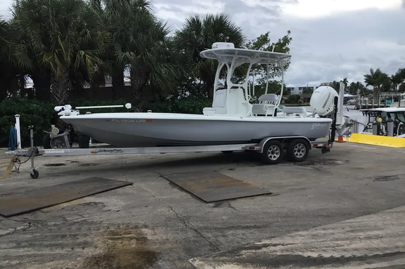 The Image of 2020 Yellowfin 24 Bay CE boat on trailer, parked near palm trees. - 0