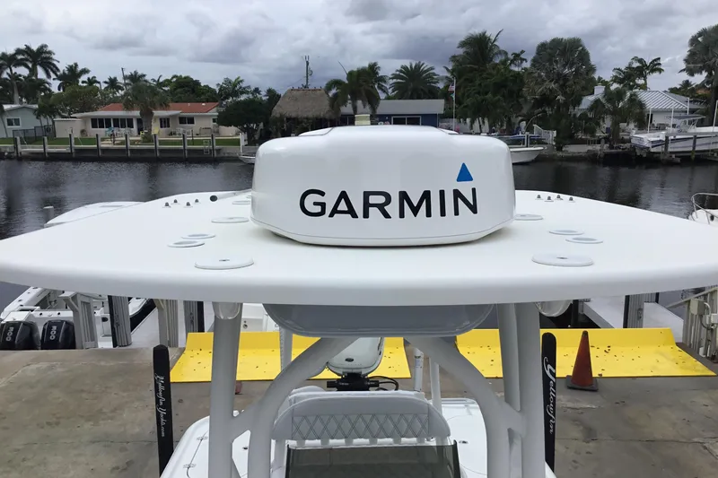 Slide: The Image of 2020 Yellowfin 24 Bay CE boat with Garmin radar, docked by waterfront homes. - 20