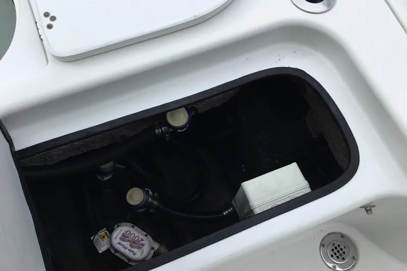 Slide: The Image of 2020 Yellowfin 24 Bay CE boat compartment with visible plumbing and wiring. - 25