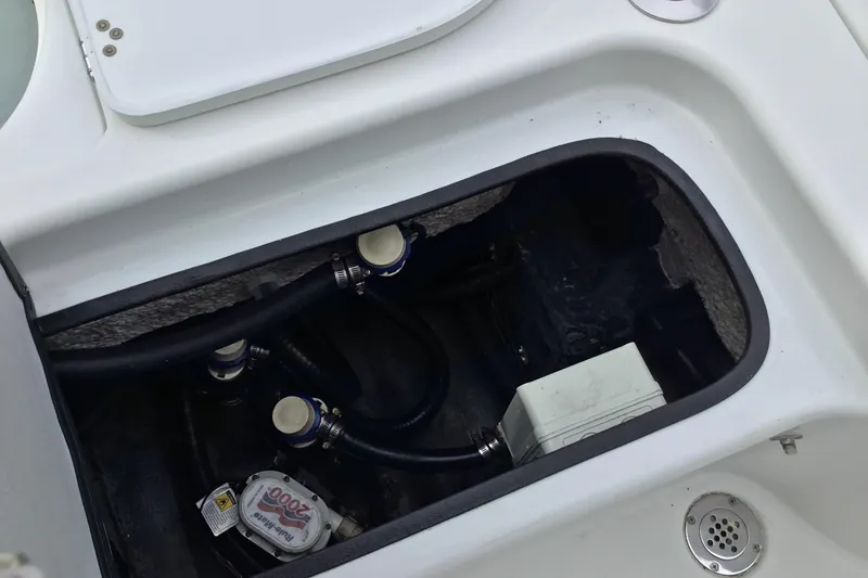 Slide: The Image of 2020 Yellowfin 24 Bay CE boat compartment with hoses and pump system. - 26