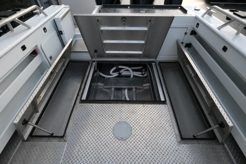 Slide: The Image of 2023 Hewescraft 270 Alaskan ET HT boat interior with open storage compartments and diamond plate flooring. - 13