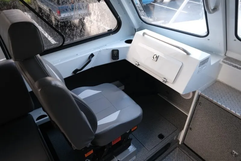 Slide: The Image of 2023 Hewescraft 270 Alaskan ET HT interior with gray seating and storage compartment. - 21