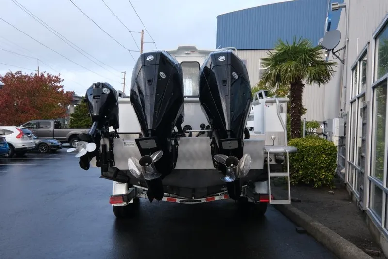 Slide: The Image of 2023 Hewescraft 270 Alaskan ET HT boat with dual outboard motors in a parking lot. - 7