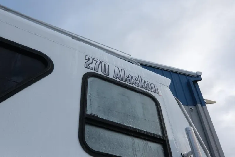 Slide: The Image of 2023 Hewescraft 270 Alaskan ET HT boat exterior with window and logo. - 9