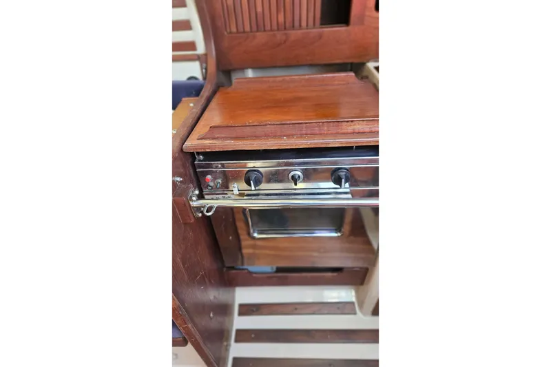 Slide: The Image of 1984 Endeavour 33 yacht interior with wooden cabinetry and built-in stove. - 10