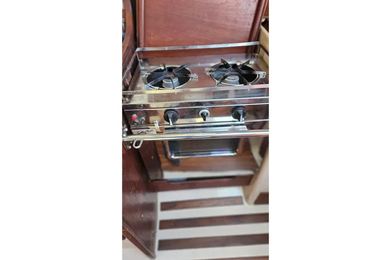 Slide: The Image of 1984 Endeavour 33 yacht kitchen with a two-burner stove and wooden cabinetry. - 11