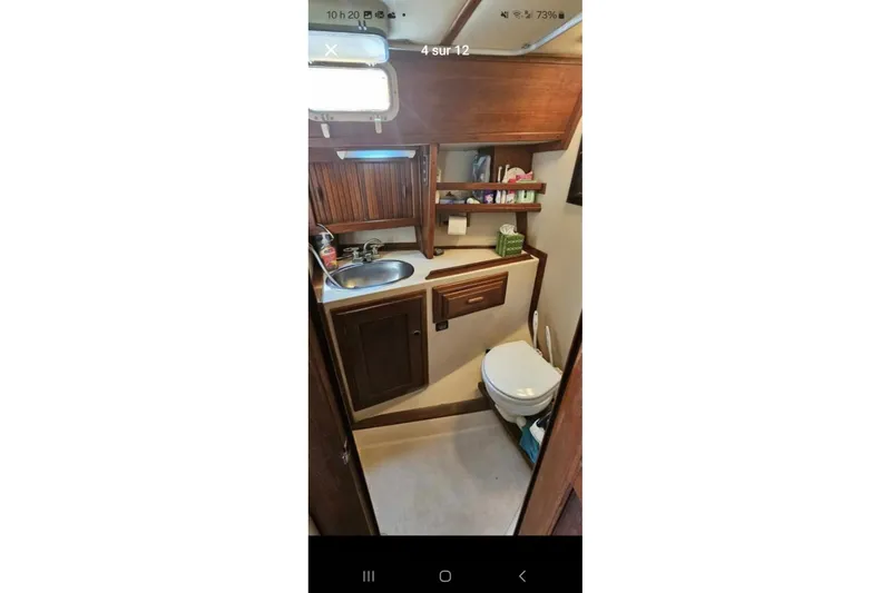 Slide: The Image of 1984 Endeavour 33 yacht bathroom with wooden cabinets, sink, and toilet. - 25