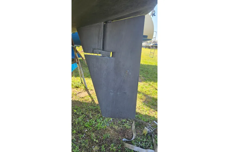 Slide: The Image of Rudder of 1984 Endeavour 33 sailboat on grassy ground. - 27