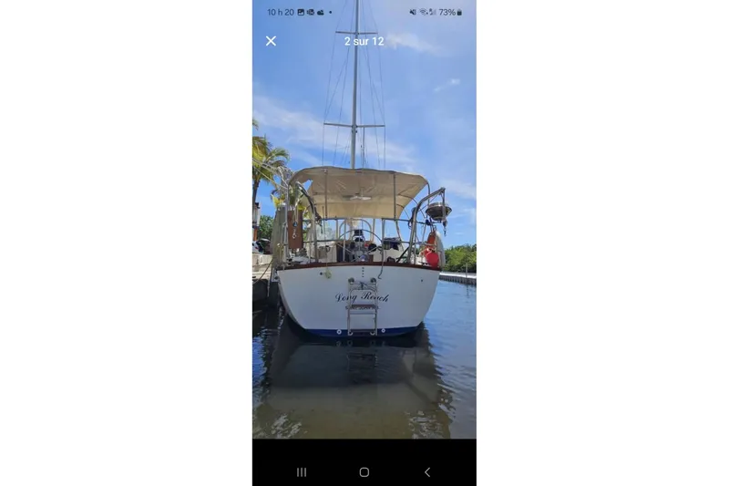 Slide: The Image of 1984 Endeavour 33 sailboat docked, rear view with canopy, clear sky background. - 33