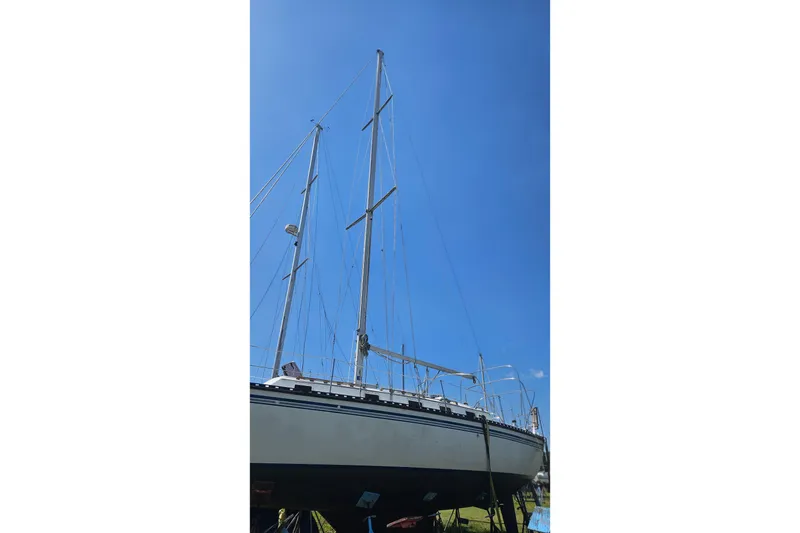 Slide: The Image of 1984 Endeavour 33 sailboat with tall masts against a clear blue sky. - 4