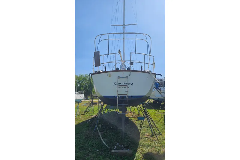 Slide: The Image of 1984 Endeavour 33 sailboat on land, viewed from the stern, under clear blue sky. - 5