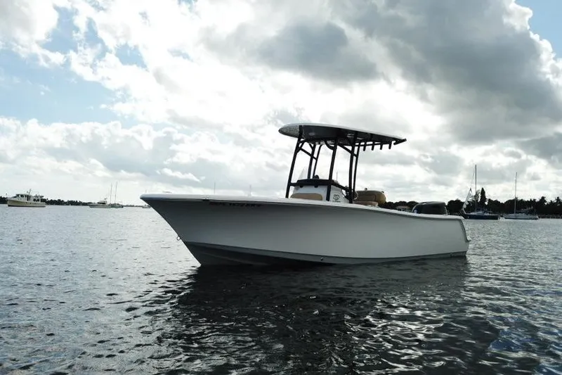 The Image of 2019 Sportsman Heritage 231 Center Console boat on calm water under cloudy sky. - 0