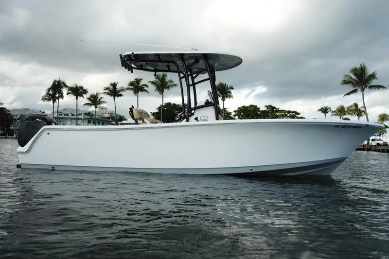 Slide: The Image of 2019 Sportsman Heritage 231 Center Console boat on water, with palm trees in background. - 11