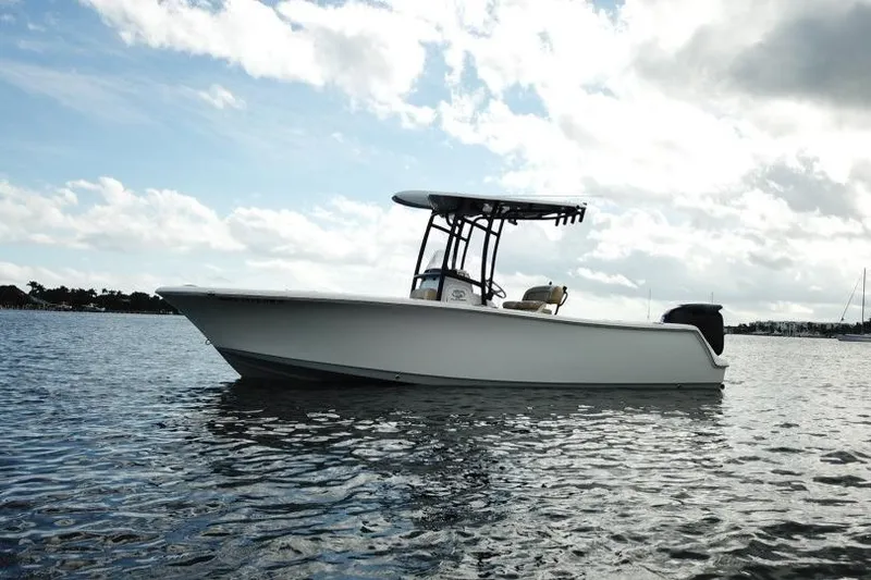 Slide: The Image of 2019 Sportsman Heritage 231 Center Console boat on calm water under cloudy sky. - 2