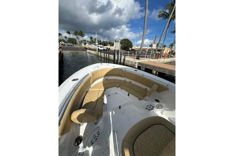 Slide: The Image of 2019 Sportsman Heritage 231 Center Console boat docked, featuring tan seating and clear skies. - 5