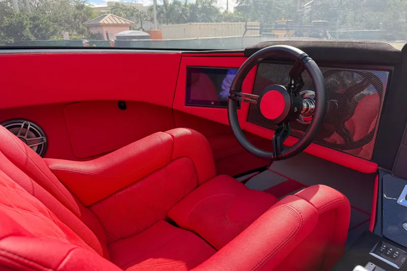 Slide: The Image of Red interior of a 2022 Doug Wright 320, featuring a sleek steering wheel and modern dashboard. - 12
