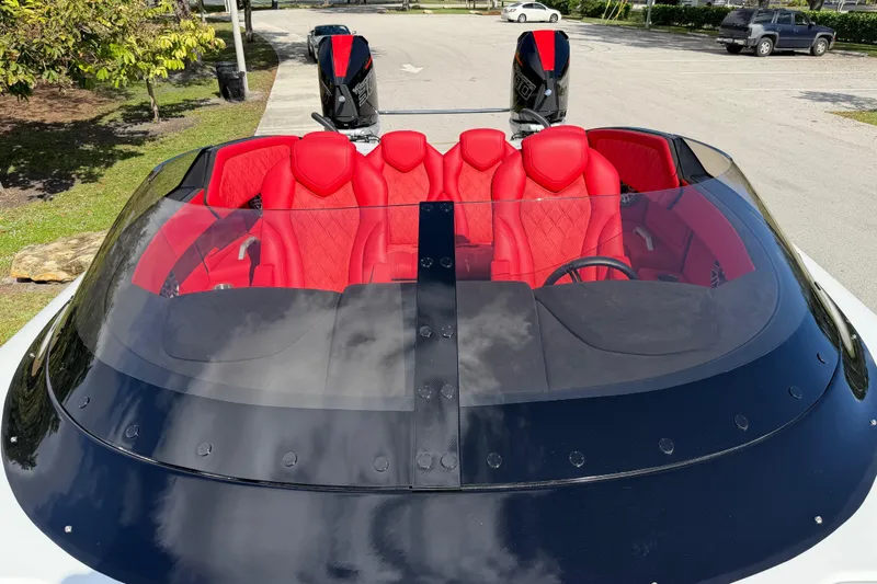 Slide: The Image of 2022 Doug Wright 320 boat with red interior and dual engines in a parking area. - 17