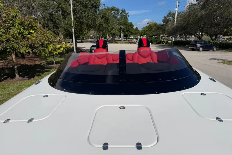 Slide: The Image of 2022 Doug Wright 320 boat with red seats and sleek design, parked outdoors. - 18