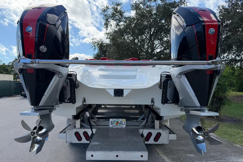 Slide: The Image of 2022 Doug Wright 320 boat with dual outboard engines, parked outdoors. - 6