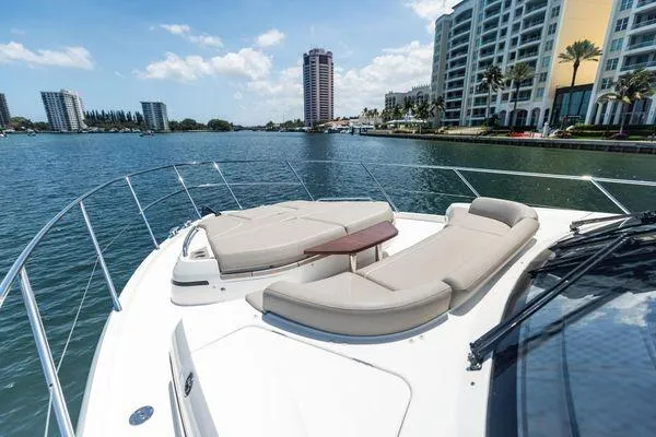 Slide: The Image of Luxurious 2020 Princess V55 yacht with sun loungers, cruising near waterfront buildings. - 14