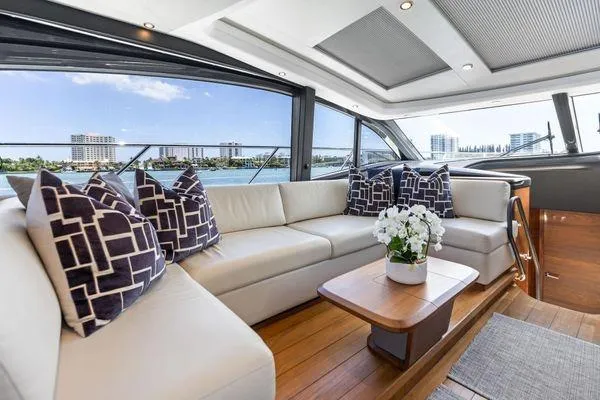 Slide: The Image of Luxurious 2020 Princess V55 yacht interior with elegant seating, decorative pillows, and scenic ocean view. - 21