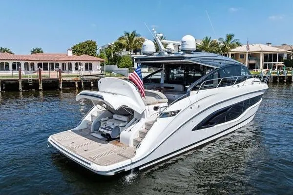 Slide: The Image of Luxury 2020 Princess V55 yacht docked on serene waterfront with American flag. - 3
