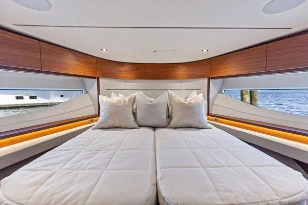 Slide: The Image of Luxurious 2020 Princess V55 yacht bedroom with elegant bedding and wood accents. - 37