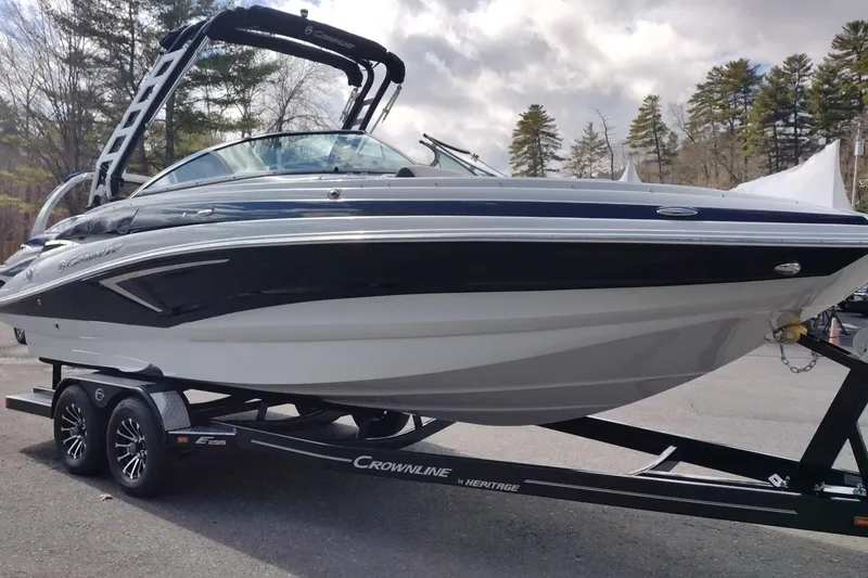 Slide: The Image of 2026 Crownline Eclipse E255 boat on trailer, parked outdoors. - 23