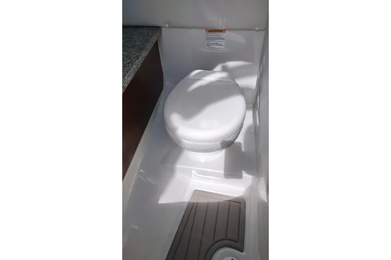 Slide: The Image of 2026 Crownline Eclipse E255 boat interior with compact marine toilet. - 40