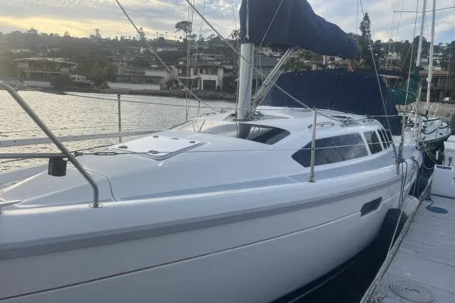 Slide: The Image of Sleek 1995 Hunter 336 sailboat docked at marina, showcasing modern design and white hull. - 23