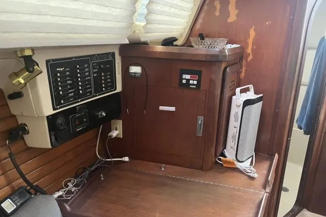 Slide: The Image of Interior of a 1995 Hunter 336 sailboat with control panel and wooden cabinetry. - 6