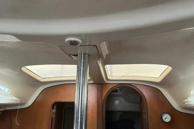 Slide: The Image of Interior view of a 1995 Hunter 336 sailboat cabin with skylights and wooden finish. - 7